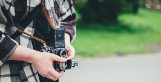 A guy holding two-lens vintage camera.